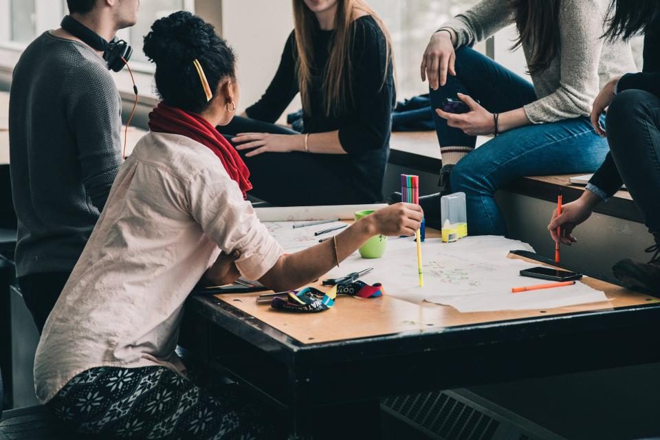 Groupe d'adolescents qui travaillent ensemble autour d'une table