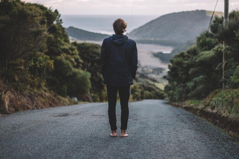 Personne debout sur une route, face au paysage, avant de choisir son chemin